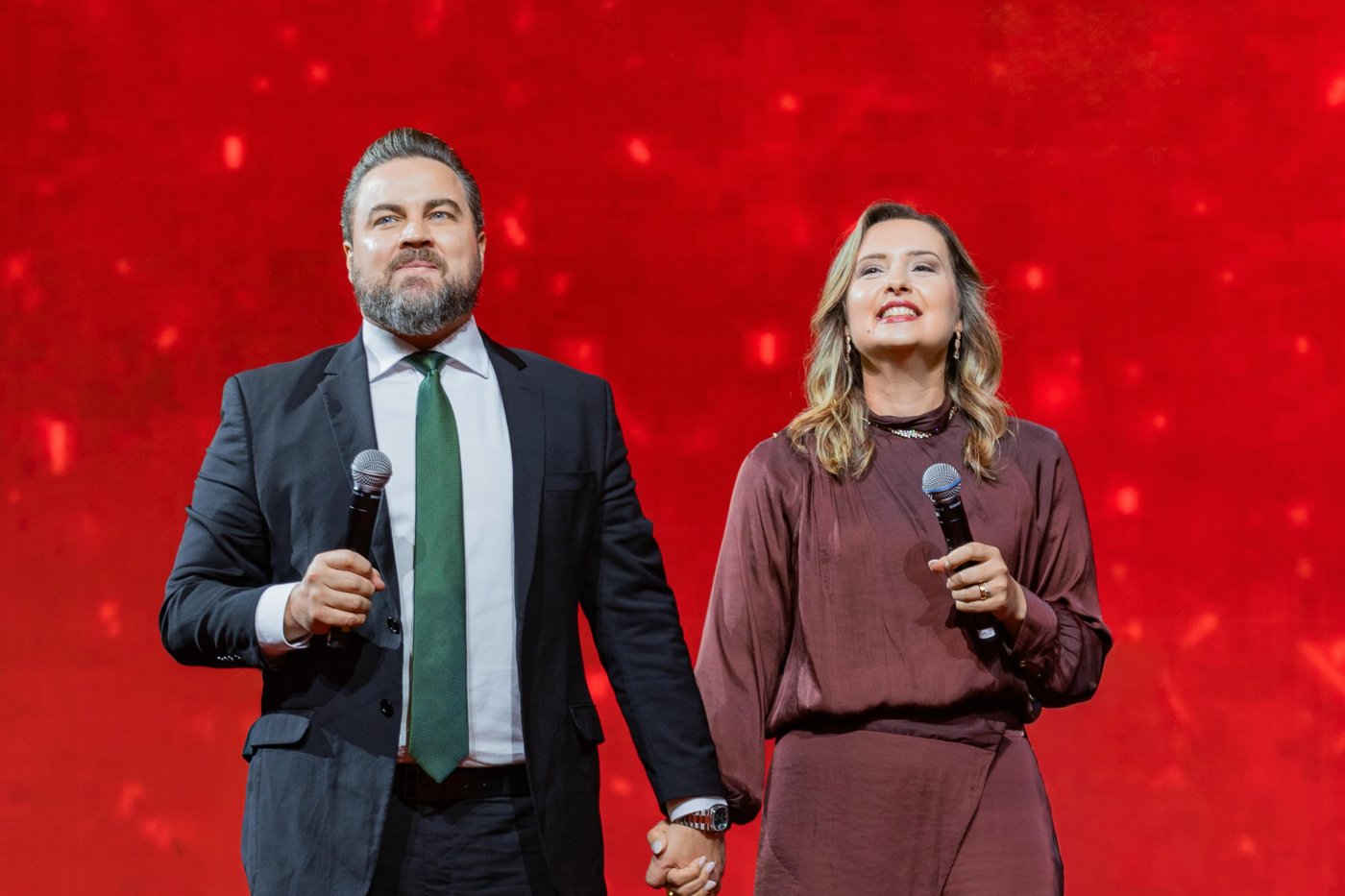 Pr. Pedro e Pra. Sara Medina no palco, de mãos dadas